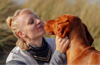 Moment complice entre une femme et son chien roux.